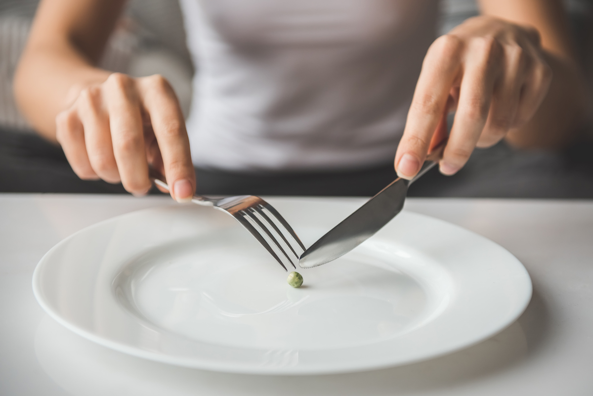 image of girl trying to put a pea on the fork